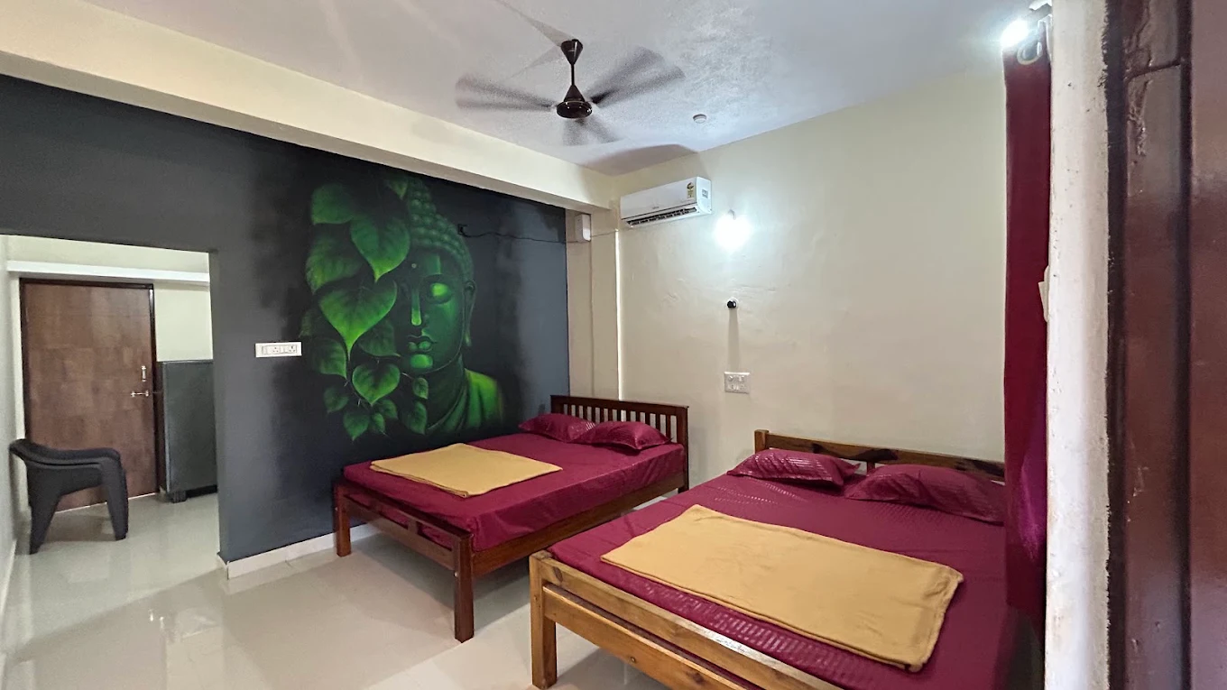 Room with two beds and green wall artwork